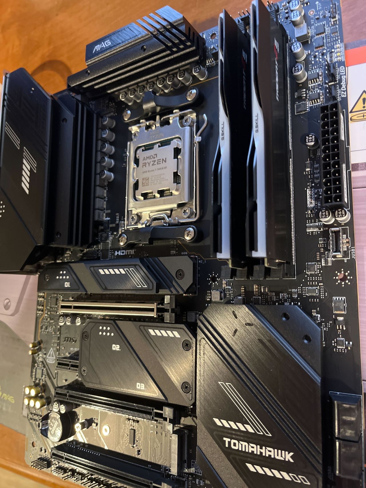 A close-up of the PC motherboard with CPU and RAM installed.